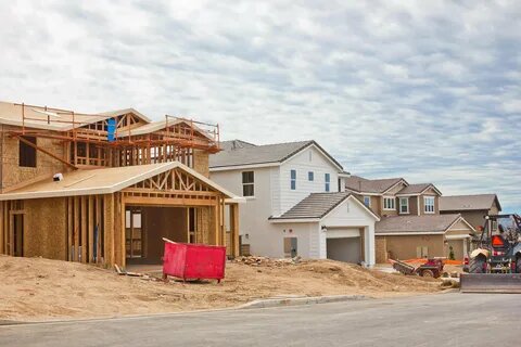 New construction homes in developing suburban neighborhood with framed houses